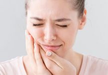 Женщина с зубной болью после установки временной пломбы